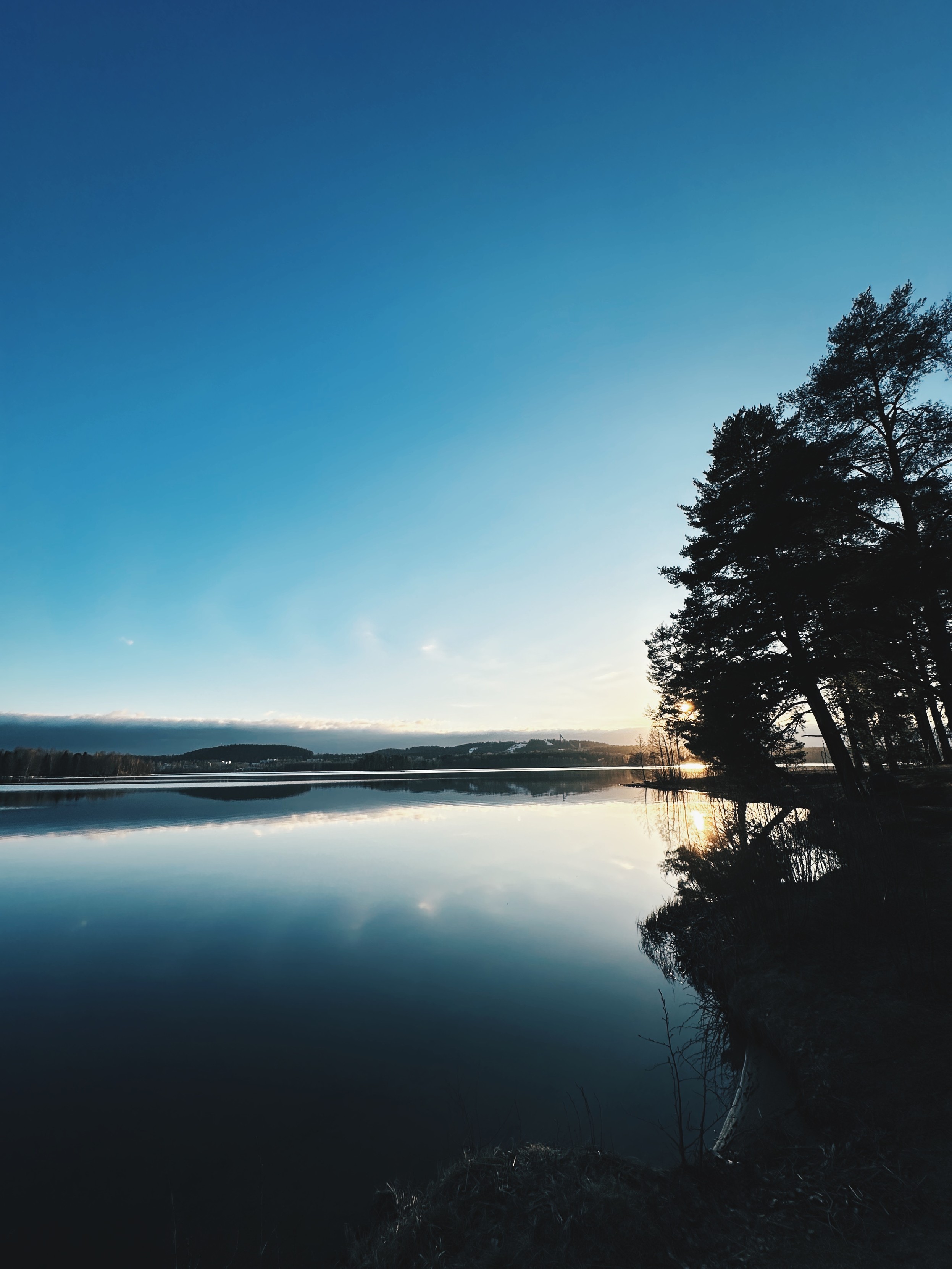 Lake Tuomiojärvi, almost mirror reflection, mostly clear blue sky
