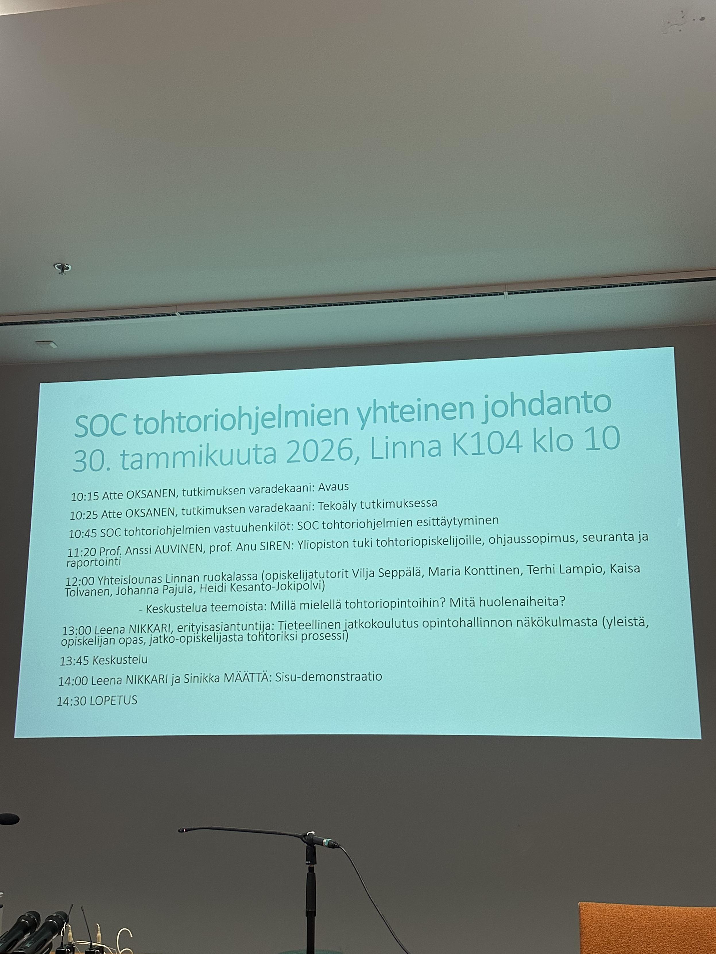 Kuva seinälle heijastetusta ohjelmasta yhteiskuntatieteiden tohtoriohjelmien yhteisestä päivästä