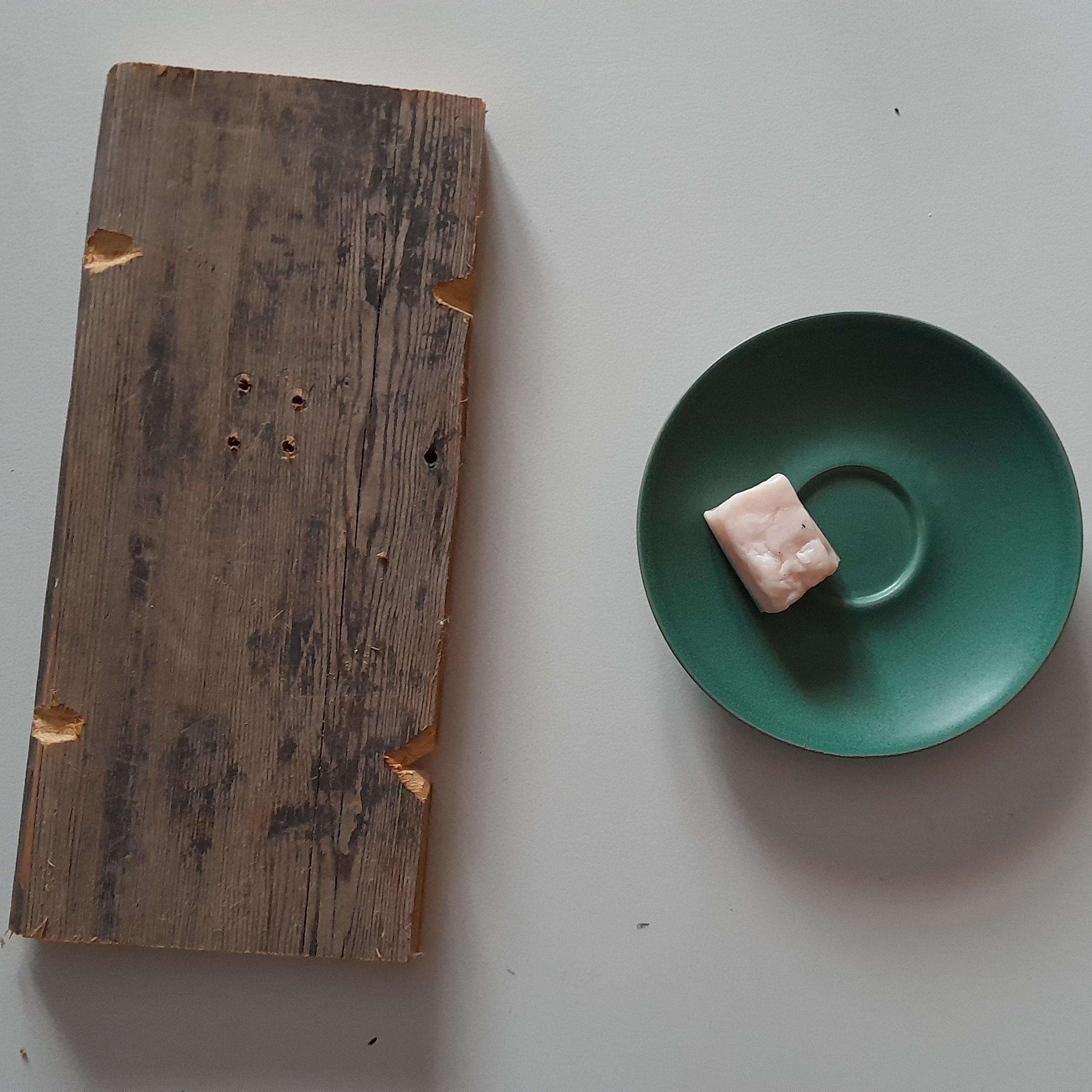 Pöydällä laudanpätkä ja pikkulautasella pala silavaa.