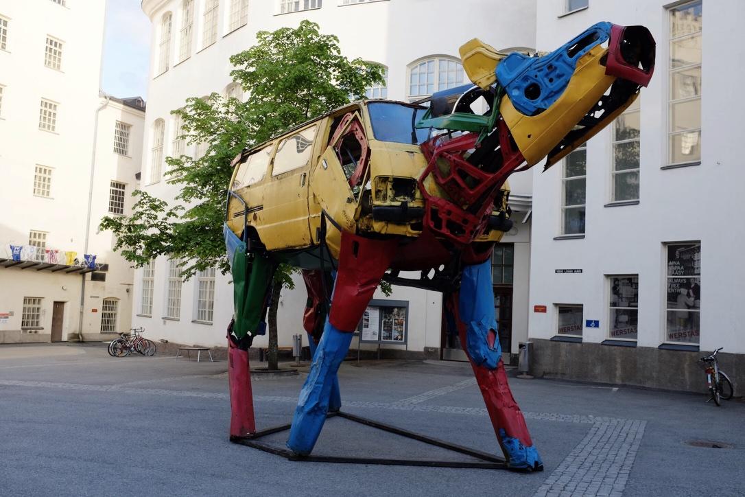 Auton osista rakennettu lehmäveistos. Kokoluokka on sellainen, että lehmän vartalo muodostuu pakettiautosta.
