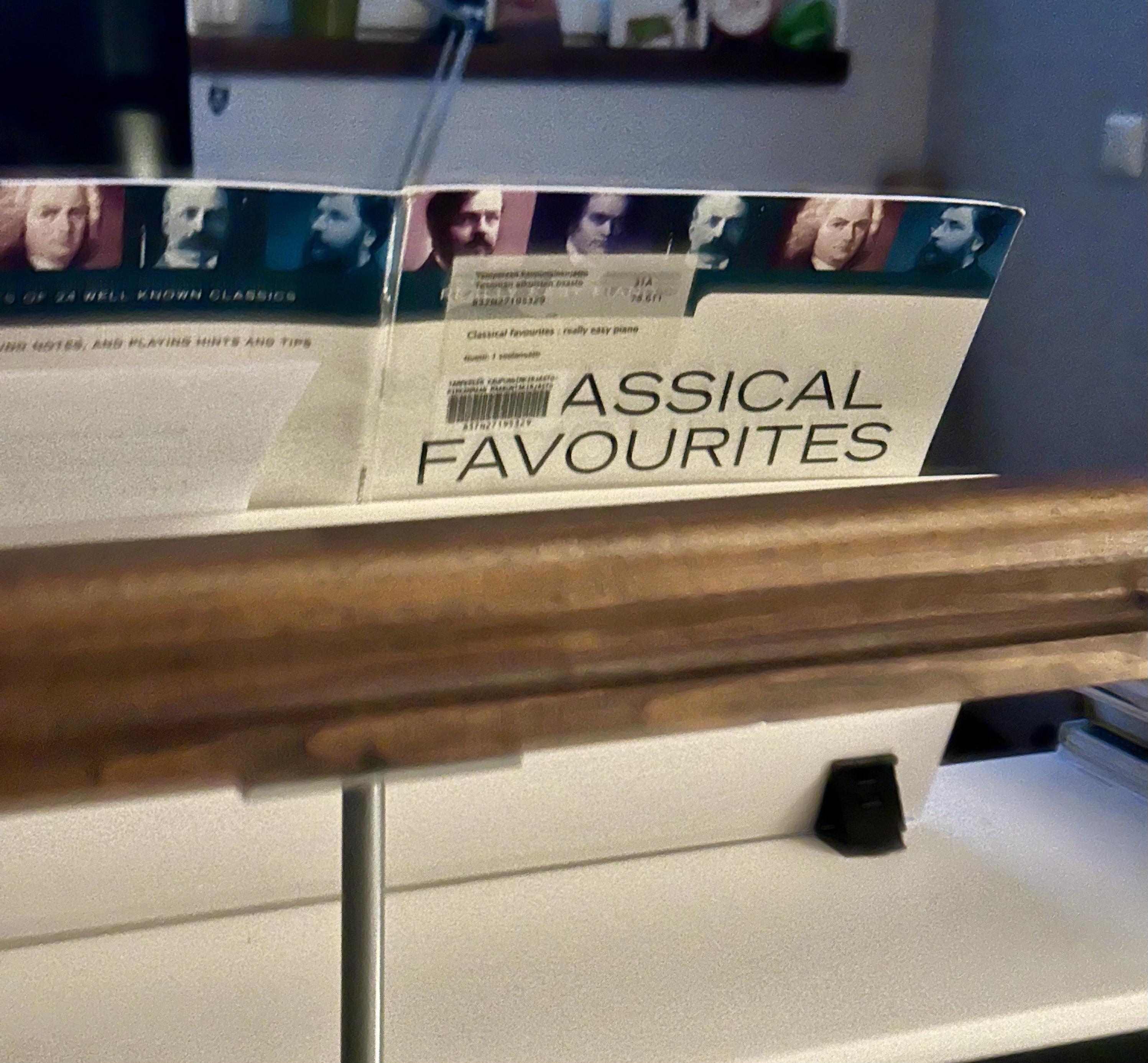 Pianon päällä nuottitelineellä nuottikirja, jonka kannessa lukee ”Assical favourites”, koska kirjaston tarrat peittävät nimen alusta kirjaimet ”Cl”.