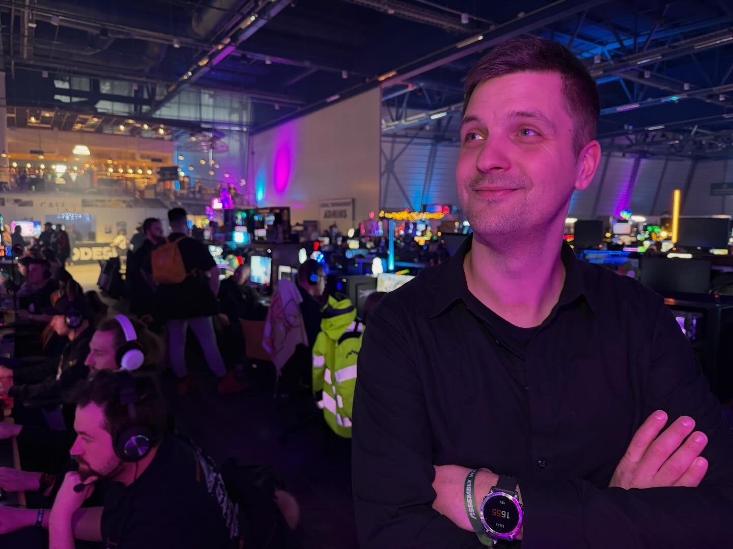 Minä seisomassa lanihallissa hymyillen. Takana tietokoneita.