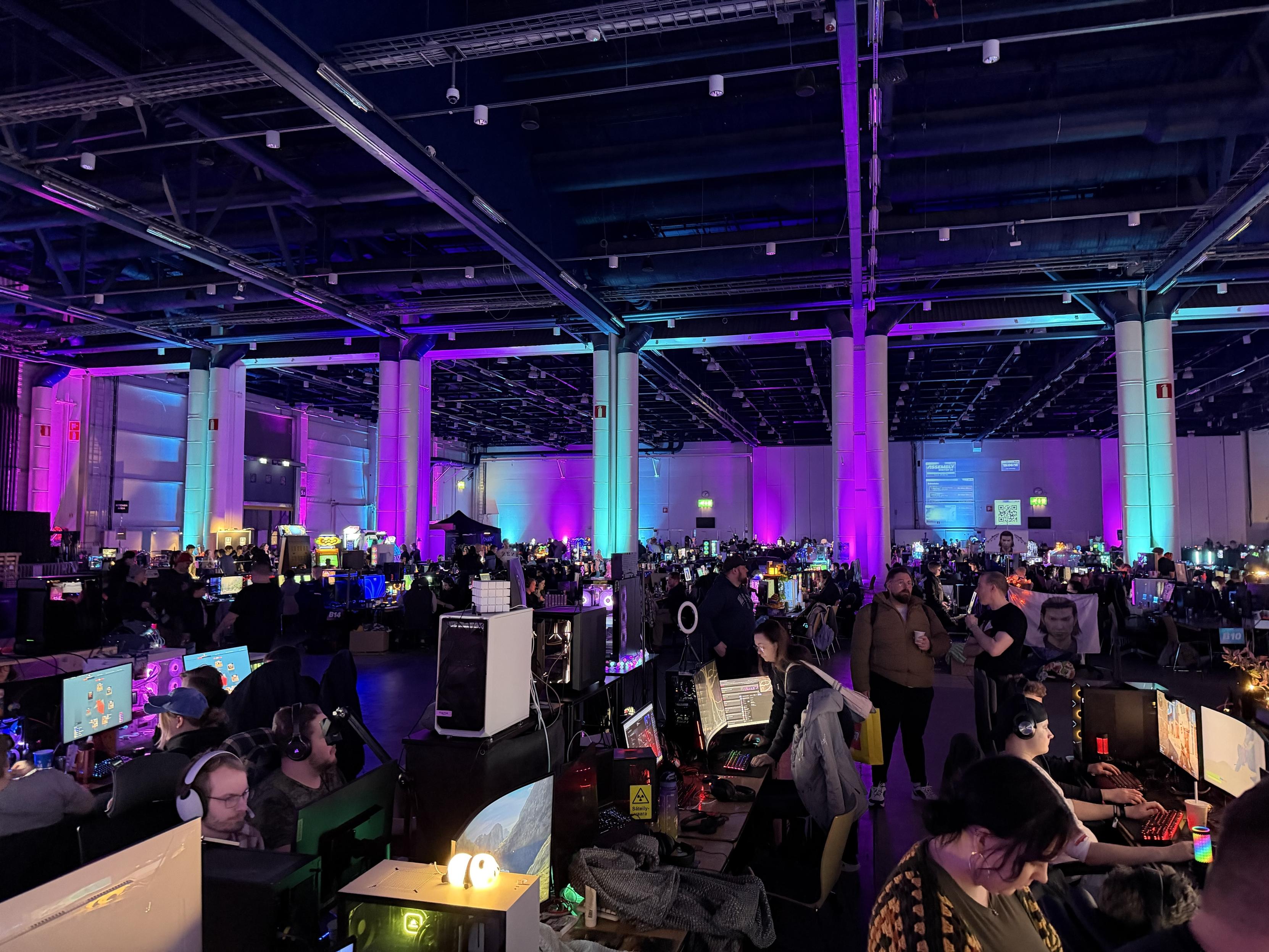 Lanihalli täynnä tietokoneita ja värivalojen luomaa tunnelmaa. Helsingin Messukeskus.