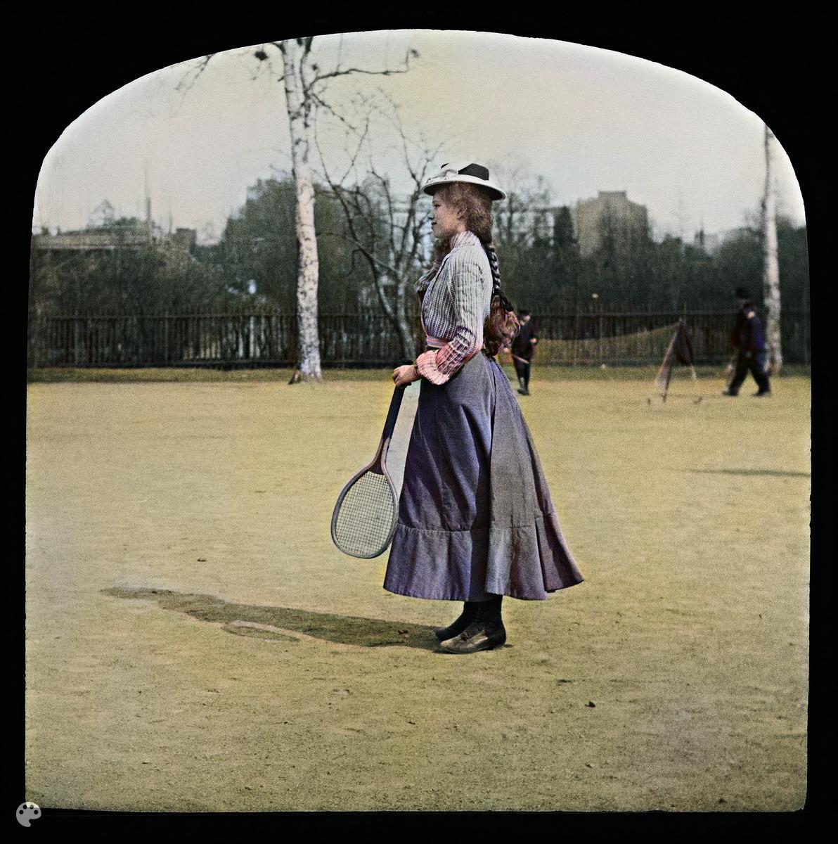 Diakuva tytöstä pelaamassa verkkopalloa (tennistä) Kaisaniemen puistossa. (1900, Helsingin kaupunginmuseo)

Alkuperäisen valokuvan on ottanut Ivan Timiriasew. Tämä kuva on keinotekoisesti väritetty DeOldify-algoritmilla.