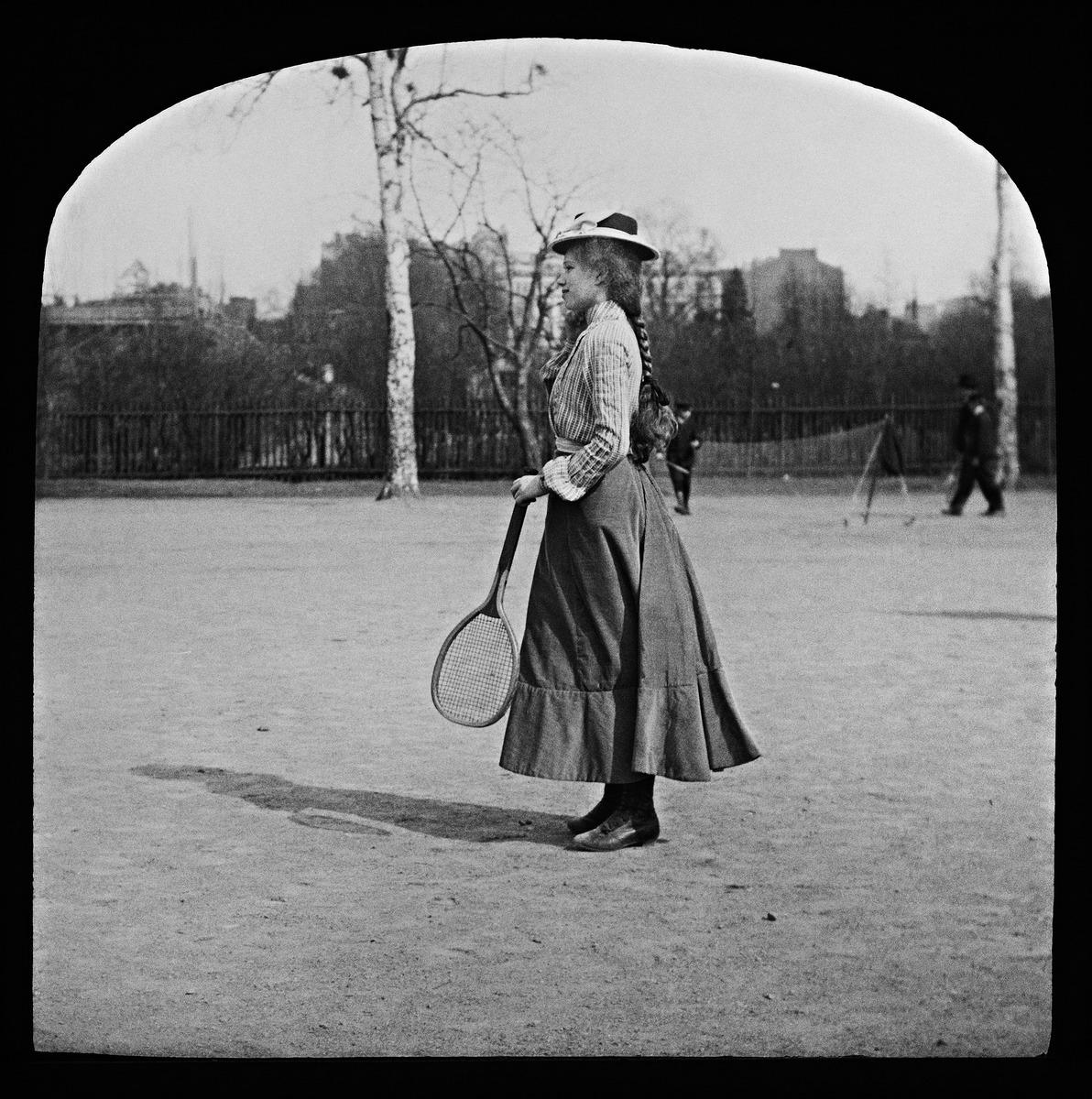 Diakuva tytöstä pelaamassa verkkopalloa (tennistä) Kaisaniemen puistossa. (1900, Helsingin kaupunginmuseo)

Alkuperäinen mustavalkoinen valokuva, jonka on ottanut Ivan Timiriasew.