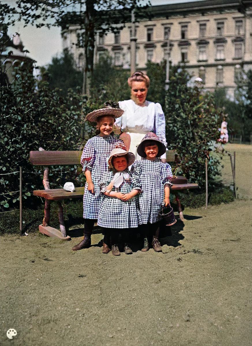 Lapsia Katajanokan puistossa lastenhoitajan tai kotiapulaisen seurassa
1910-luvulla, ks. (1910, Helsingin kaupunginmuseo)

Alkuperäisen valokuvan on ottanut Ivan Timiriasew. Tämä kuva on keinotekoisesti väritetty DeOldify-algoritmilla.