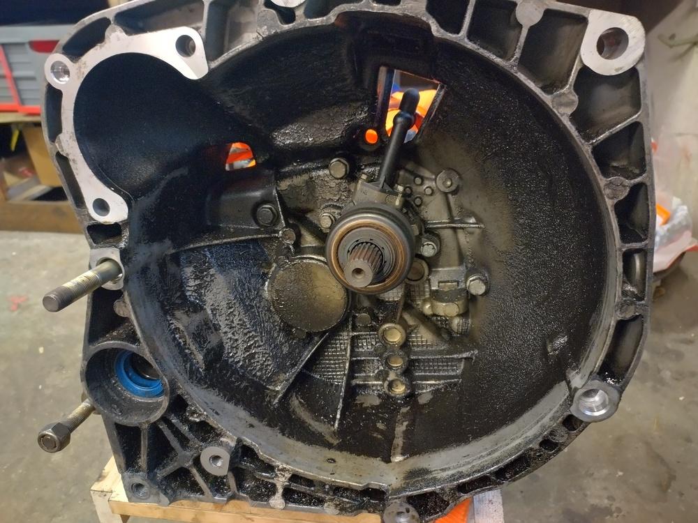 Valokuva: autosta irrotetun vaihteiston kytkinkotelo täynnä öljyistä möhmää