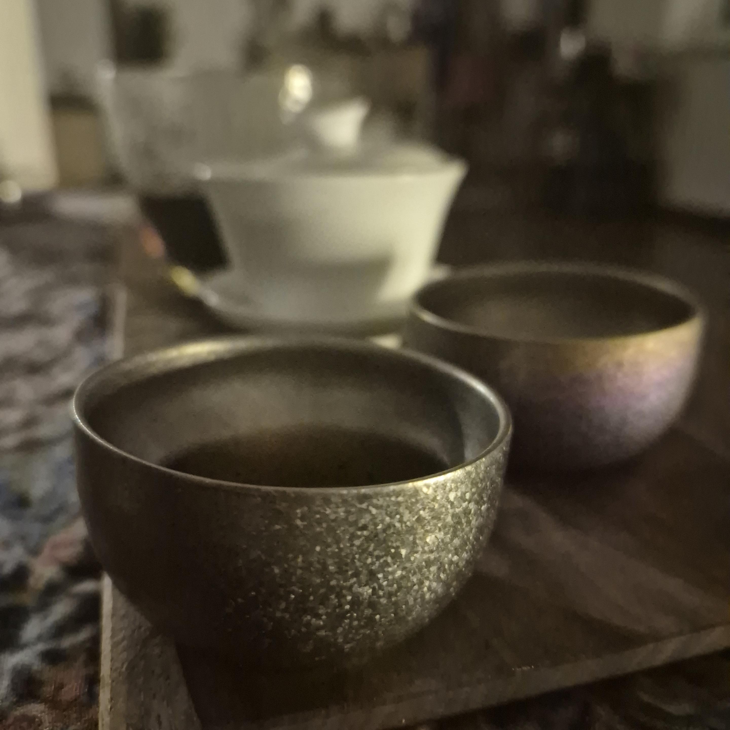 2 rather small tea cups, background is white porcelain gaiwan and faircup out of glass