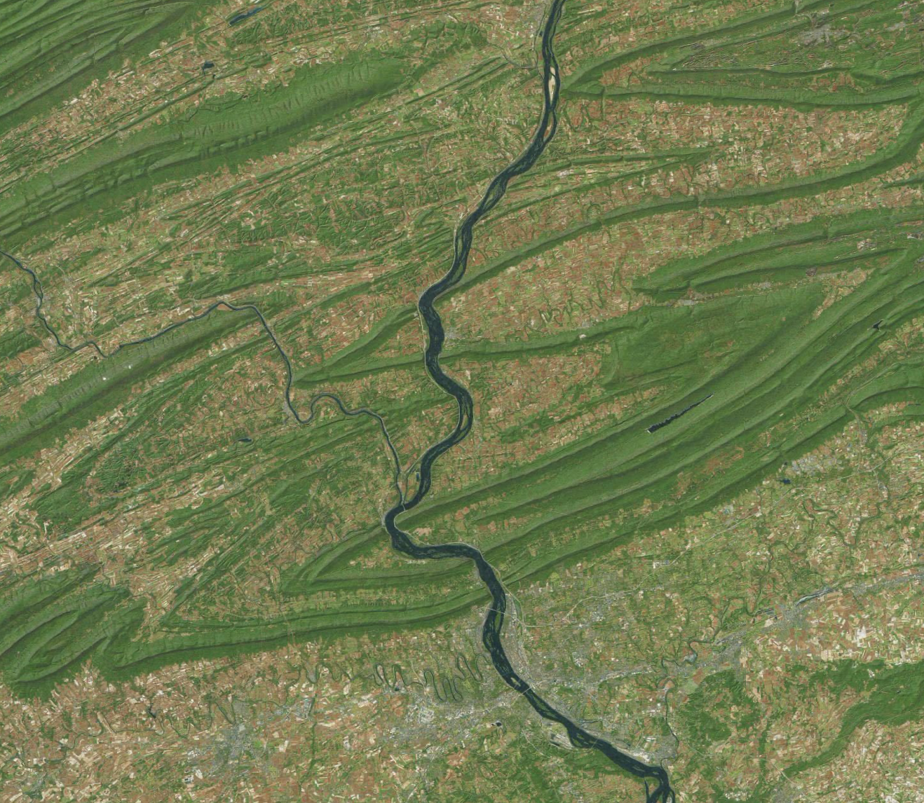 Ruudunkaappaus Apple Mapsin satelliittinäkymästä. Joki virtaa pohjoisesta etelään puhkaisten matkallaan useita metsäisiä harjanteita.