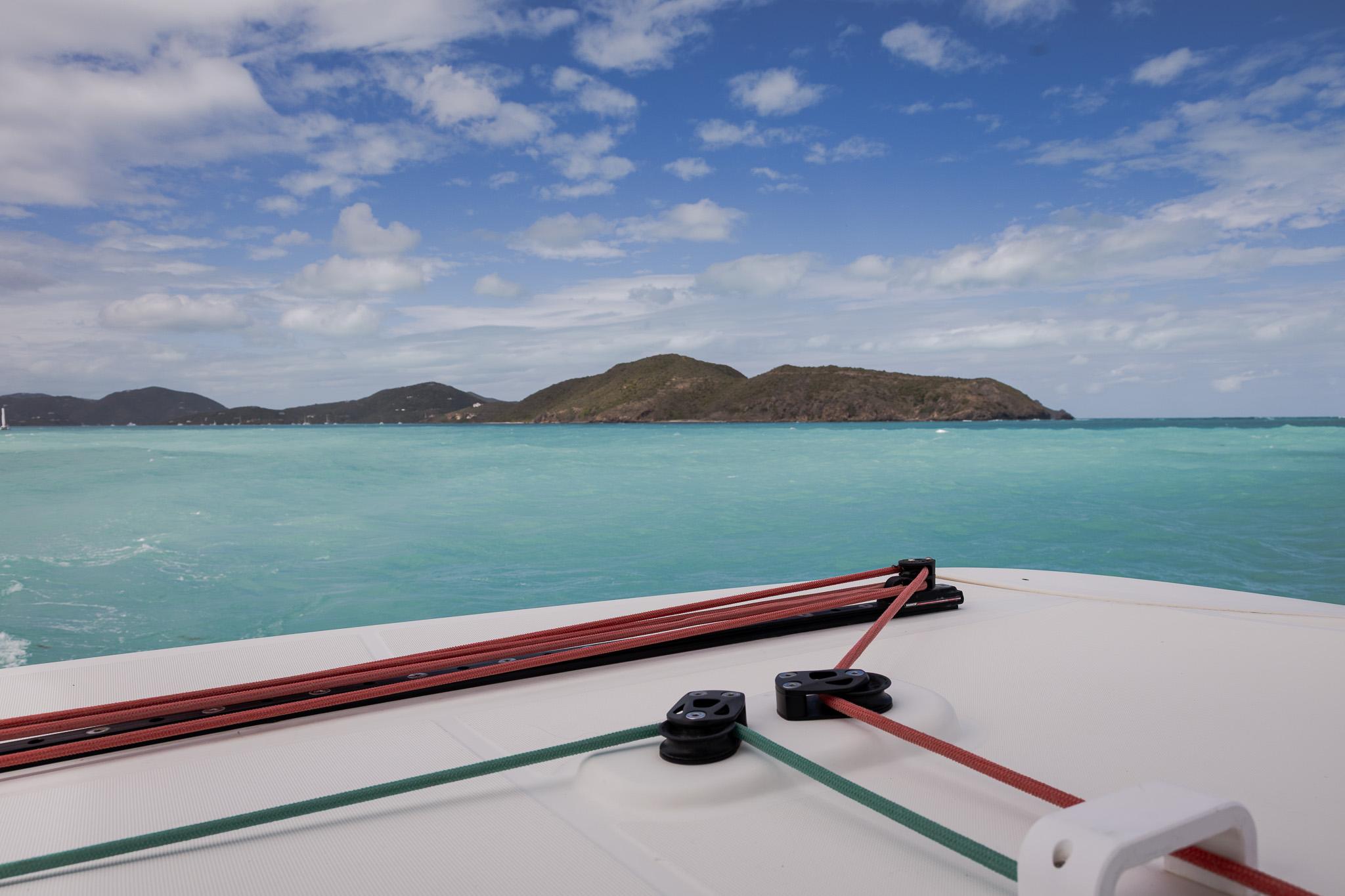 caribbean blue water with mainsail traveller on a catamaran in foreground