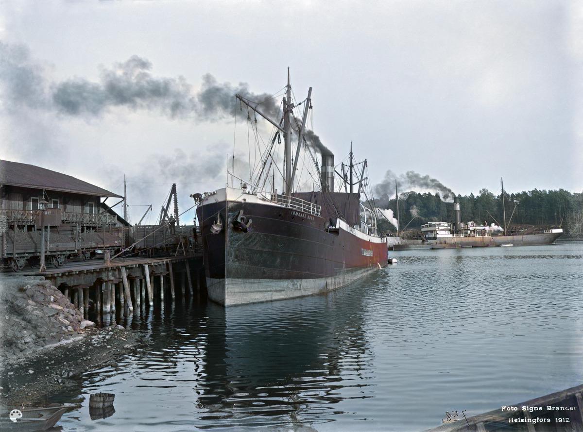 Sörnäisten satama. (1912, Helsingin kaupunginmuseo)

Alkuperäisen valokuvan on ottanut Signe Brander. Tämä kuva on keinotekoisesti väritetty DeOldify-algoritmilla.