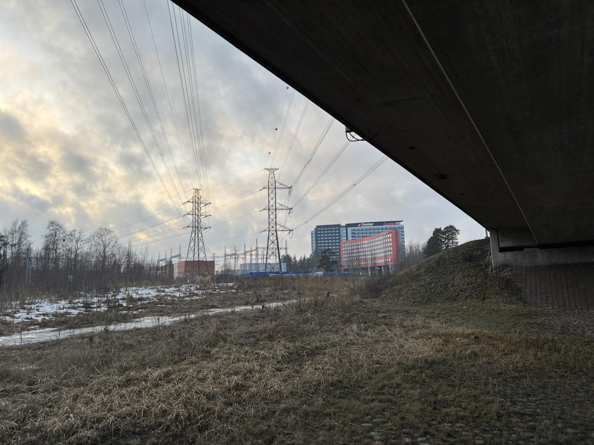 Sähköpylväät ja niiden pitämät johdot kulkevat kauas. Näkyvissä on myös Sokoksen Flamingon hotellin tornit. Valokuva otettiin tiesillan alta.