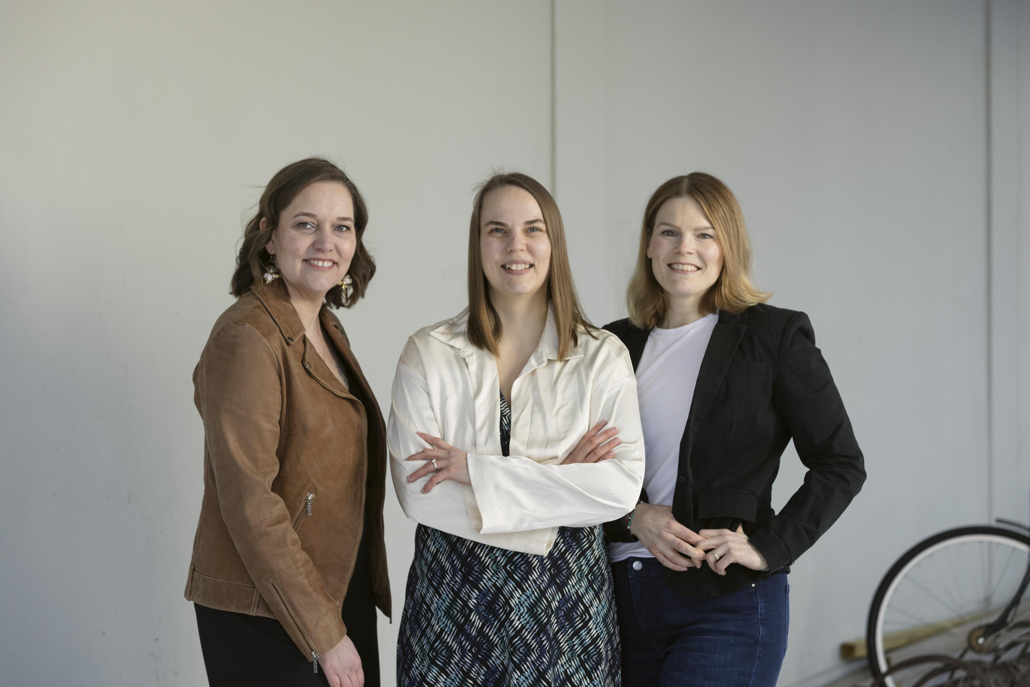 Ryhmäkuva uudesta LUVN Vasemmiston puheenjohtajistosta. Keskellä Elina Rodriguez yllään vaalea bolero ja sinimusta mekko. Vasemmalla Satu Ahjoniemi yllään ruskea takki, ja oikealla Elina Saarentaus yllään musta jakku.