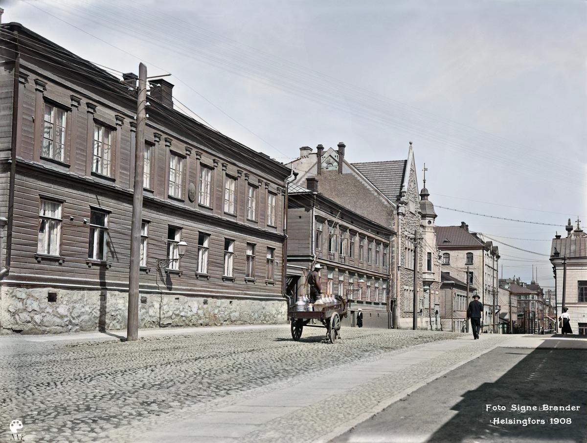 Kasarmikatu 36, 38, 40, 42. (1908, Helsingin kaupunginmuseo)

Alkuperäisen valokuvan on ottanut Signe Brander. Tämä kuva on keinotekoisesti väritetty DeOldify-algoritmilla.