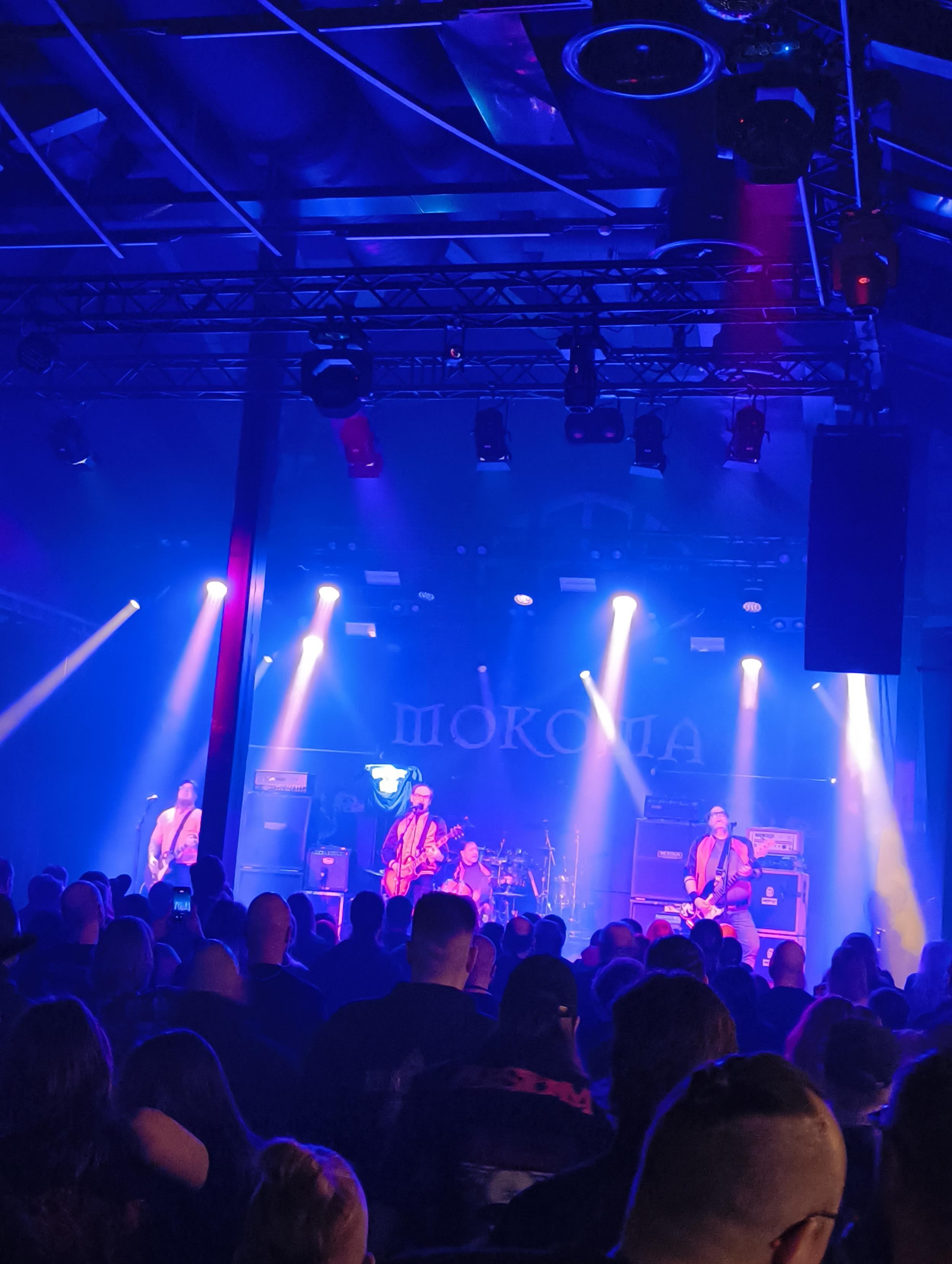 Kuva Koljosen Tiekiista -yhtyeestä esiintymässä Tampereen Tavara-Asemalla. Taustalakanassa lukee Mokoma.