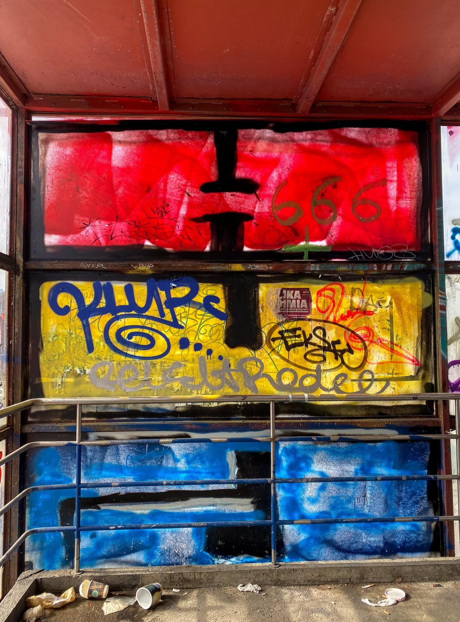 Törkyinen porrastasanne. Kolme isoa pleksilasiruutua on maalattu trikoloriksi: ylhäältä punainen, keltainen, sininen.