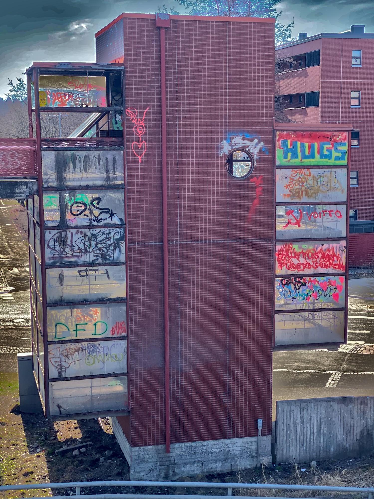 Kävelysillalle johtava noin kymmenen metriä korkea portaikkotorni. Tornin keskiosa on punatiililaatoilla päällystettyä betonia ja oikean ja vasemman puolen ulokkeet pleksiä. Pleksit on maalattu täyteen graffiteja.