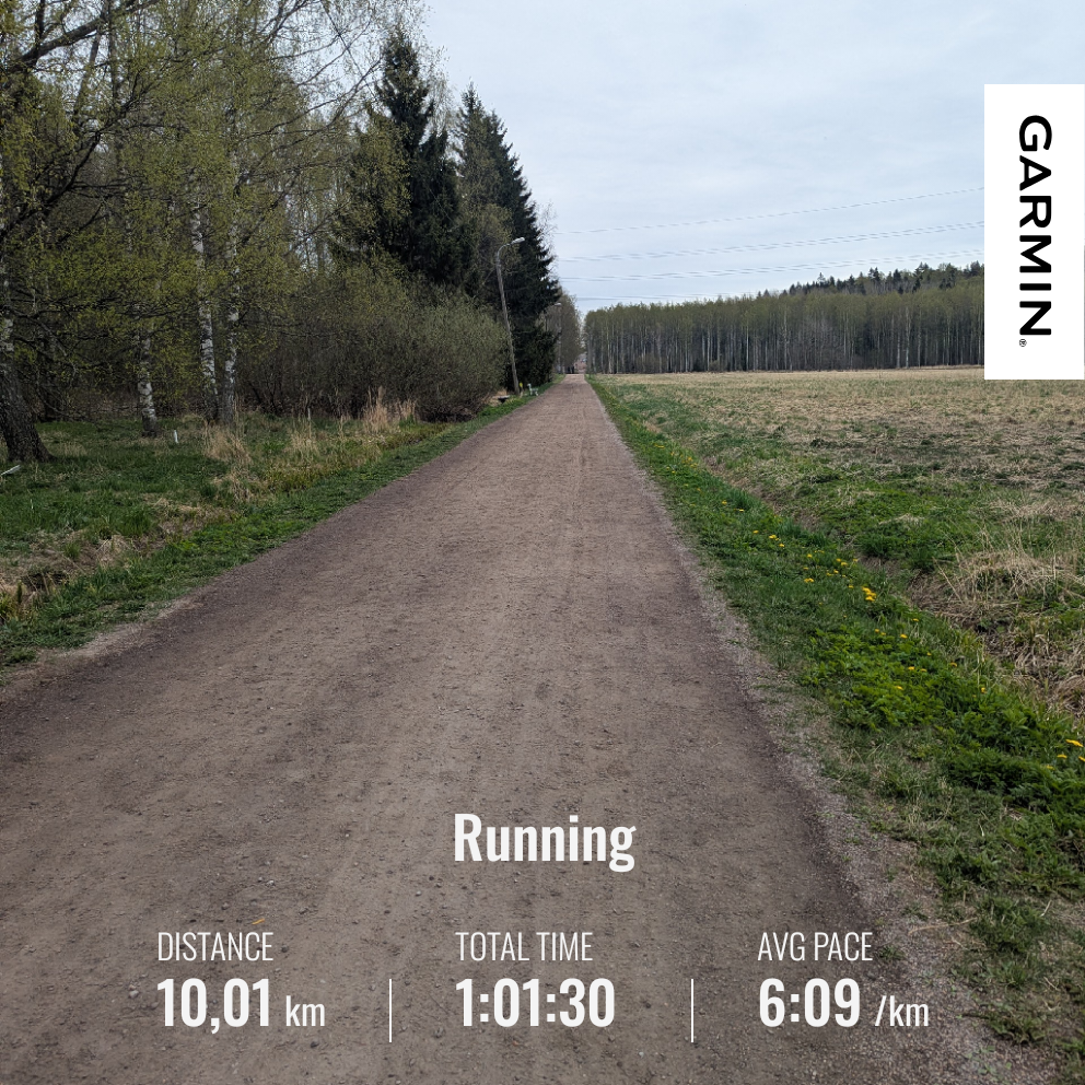 Pellon laidassa kulkeva ulkoilureitti. Tien toisella puolella on metsää. Sää on pilvinen. Juoksutilastot: matka 10,01 km, kesto 1h 1min 30 sek ja keskitahti 6:09 min/km.