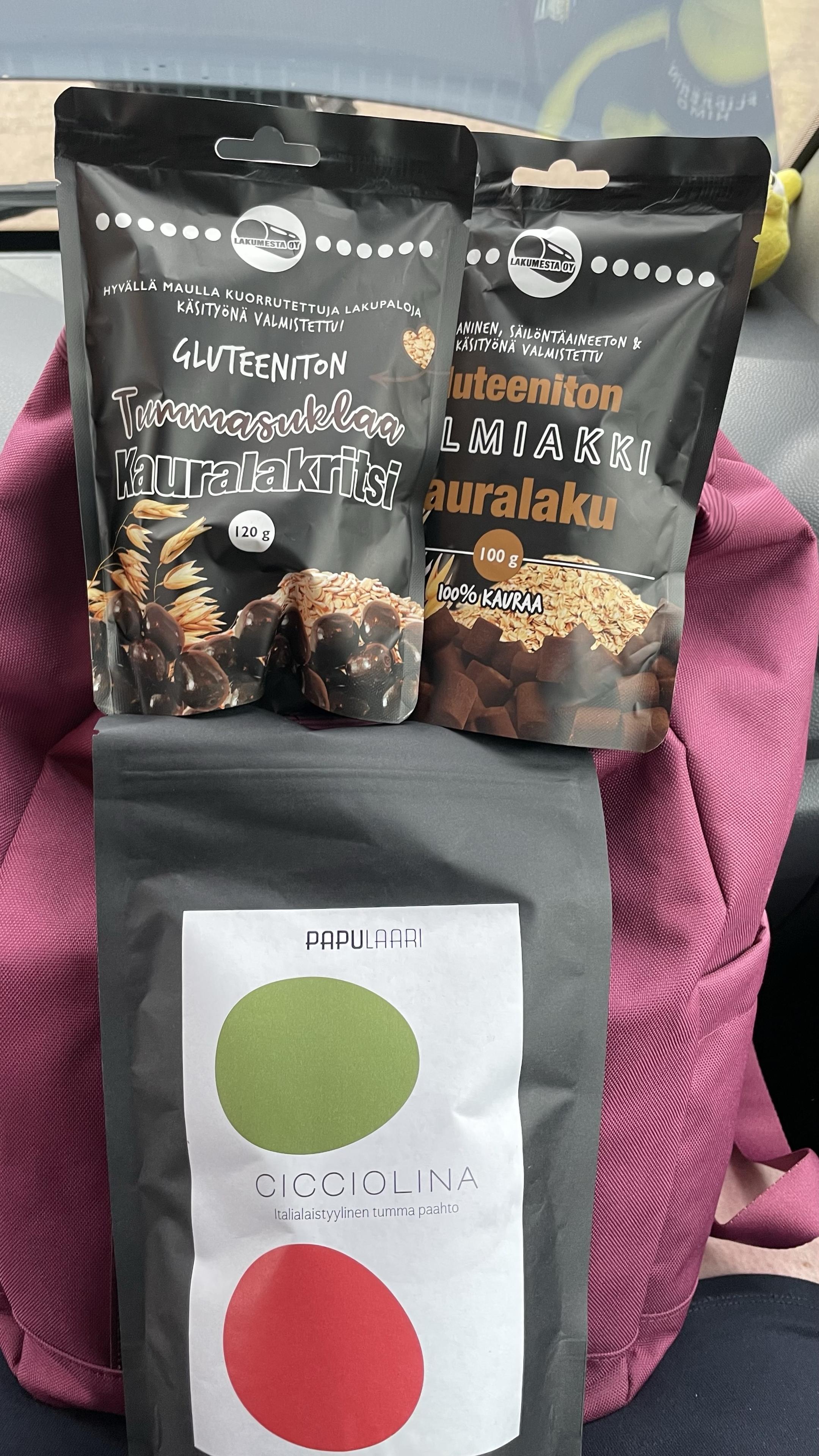 Kaksi lakupussia ja kahvipussi punaisen repun päällä.