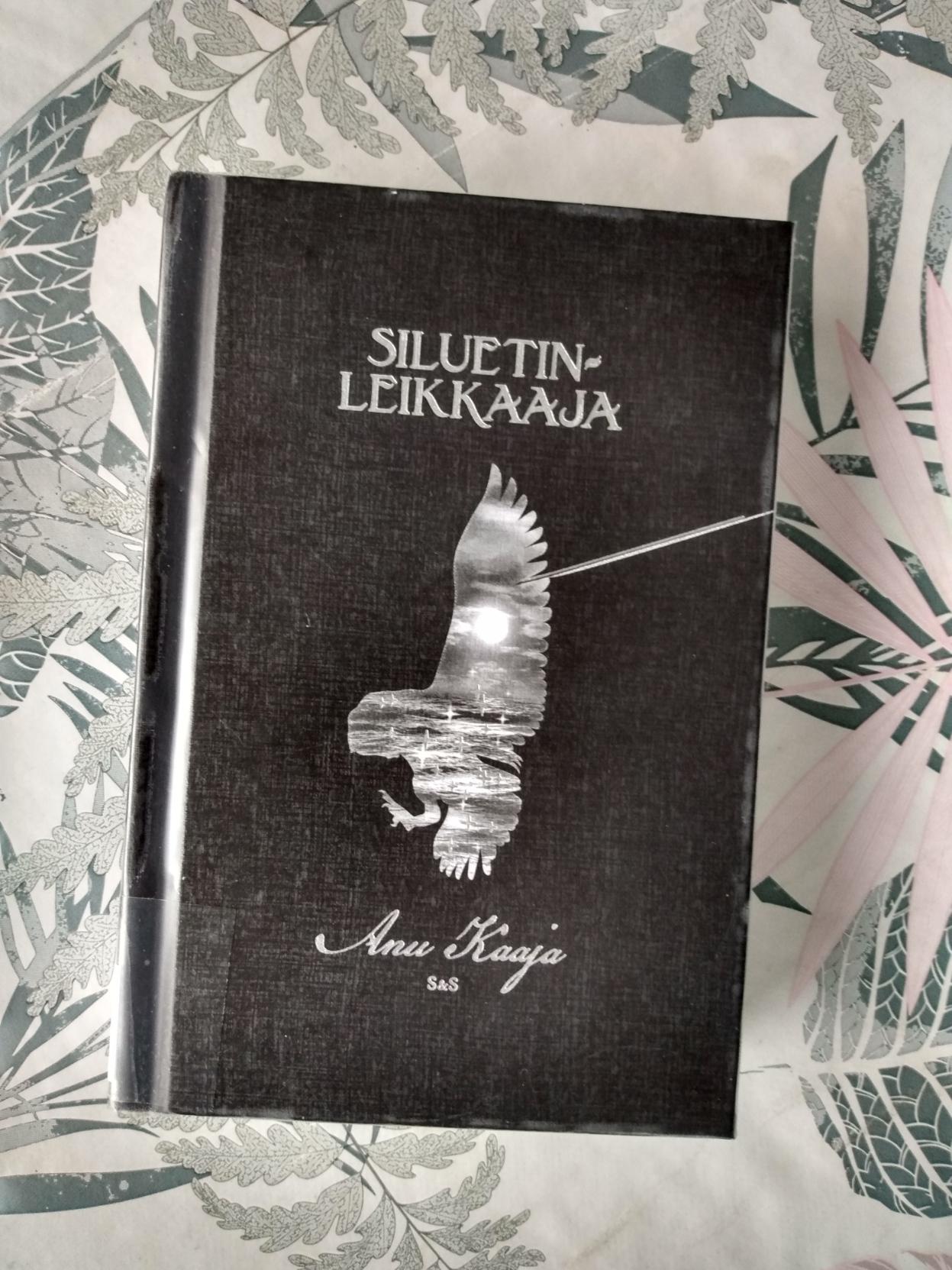 Kirjan kansi on musta ja siinä on lentävän pöllön käänteinen siluetti. Siluetin sisällä näkyy kuunpaisteessa kimalteleva meri.