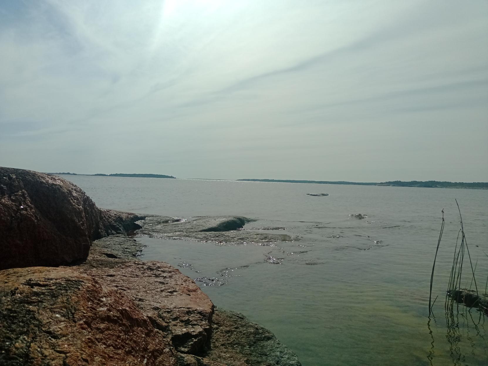 Merenrantakalliot. Taivaalla ohut pilvikerros.