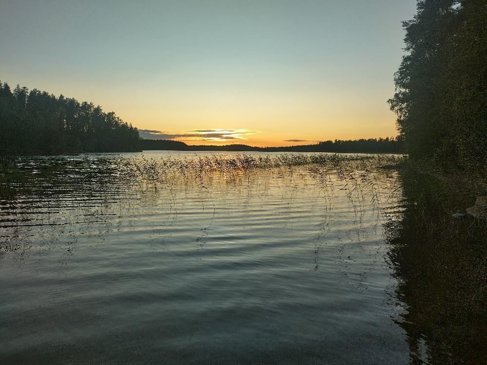 Valokuva: auringonlasku järvellä, aurinko pienen pilven takana