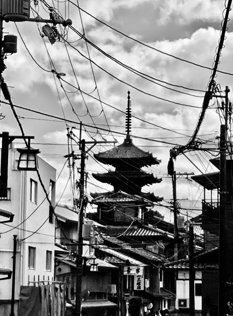 Black and white street photo from Kiyomizudera area: Yasaka Pagoda framed by a tangle of electric wires and street lights