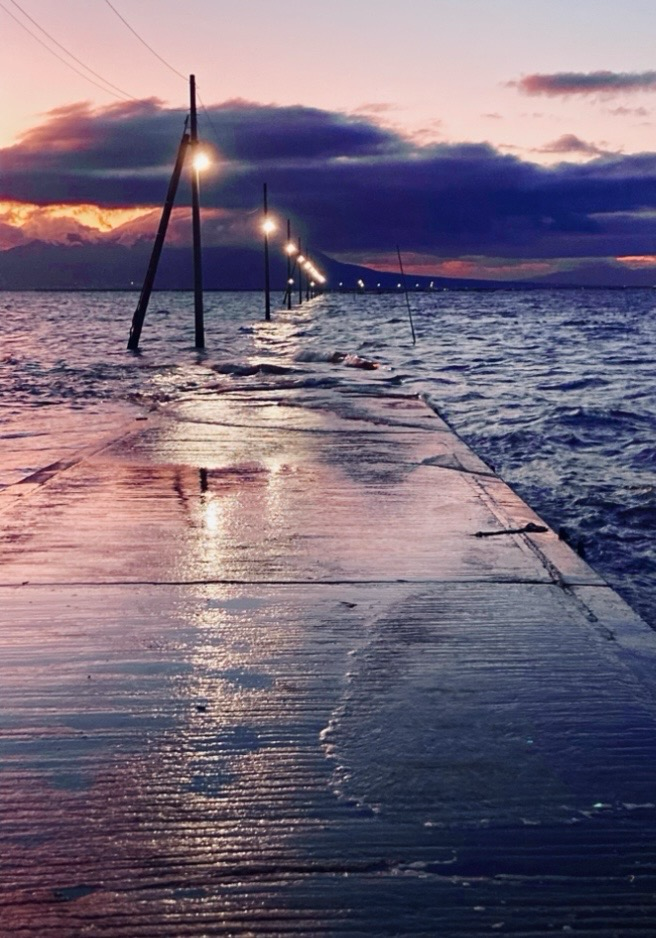 Nagabeta Sea Bed Road in Kumamoto; a paved road that gets covered by waves during high tide, so you only see a row of streetlights disappearing into distance at sunset