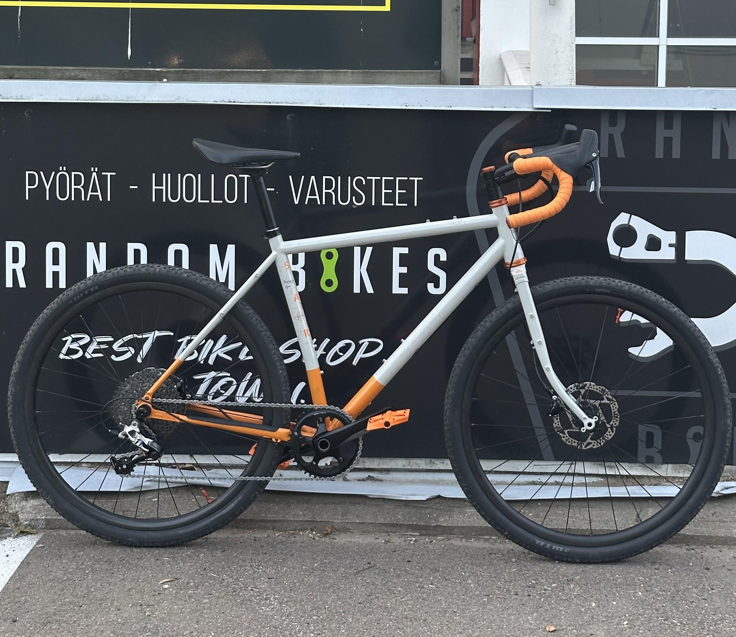 Grey and orange bike leaning against a wall